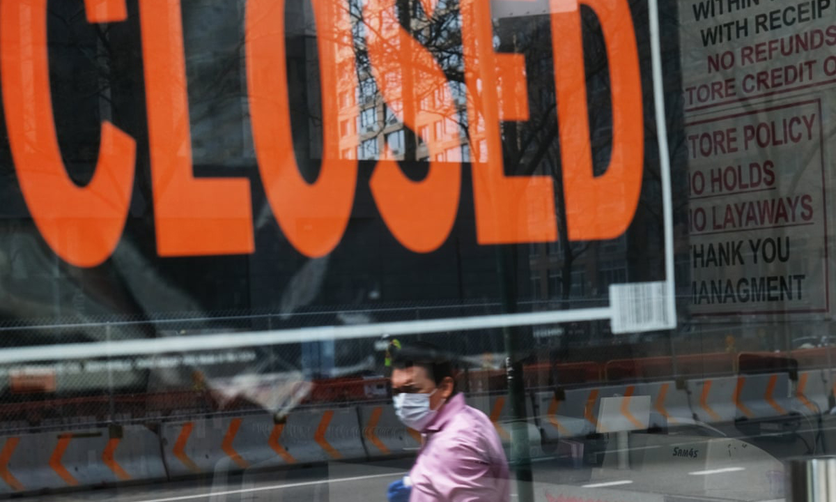 Covid Economic Recovery Window into a business with a closed sign and a worker with a mask on