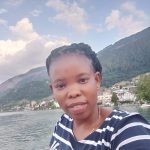 Photo of woman smiling with lake in the background