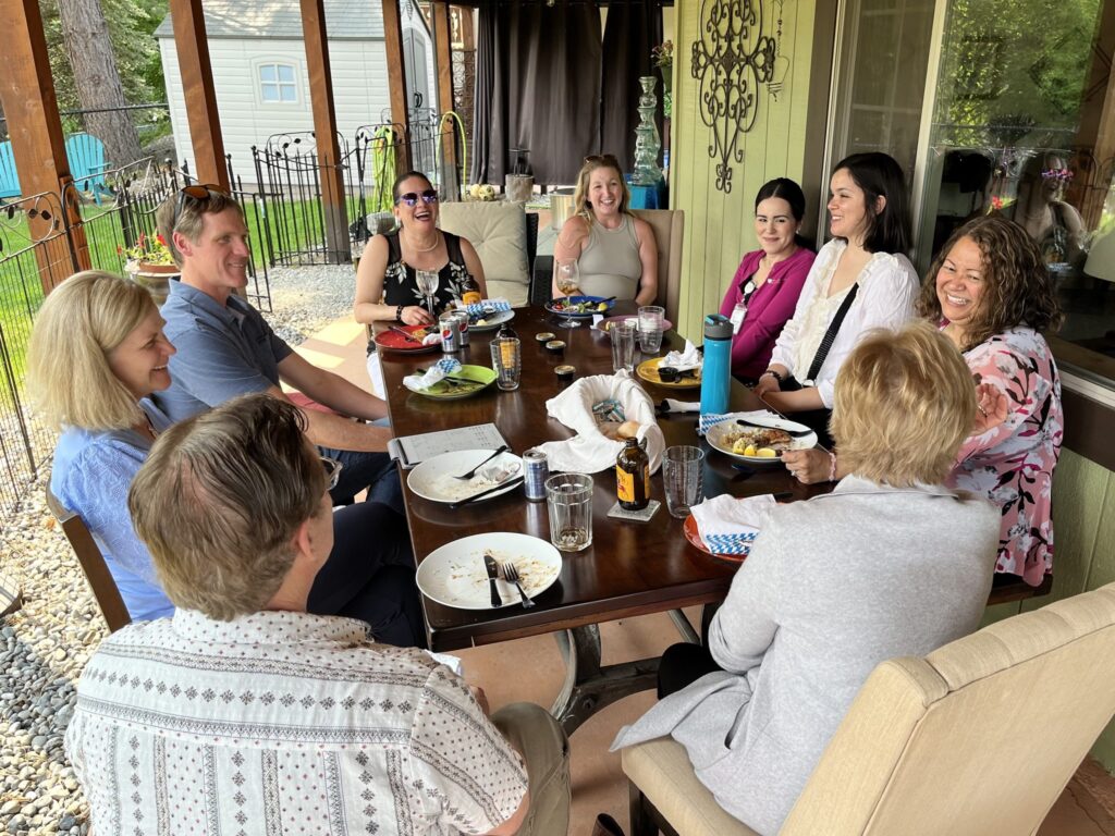 Alumni sitting in conversation around a table after a meal talking with Dean Jodi Sandfort