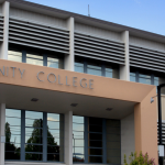 Two story modern building with sign over entrance saying Community College