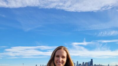 Allie Tripp holding her new book with the Seattle skyline in the background