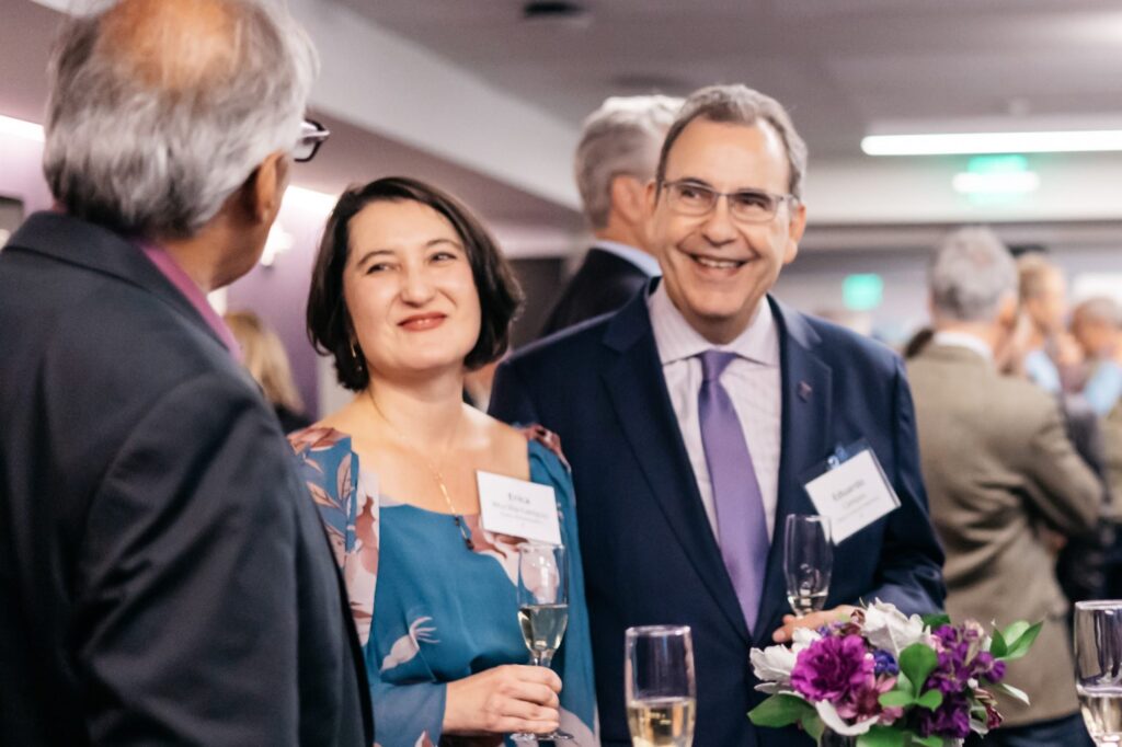 Eduardo and Erica Campos chat with a fellow Evans event attendee while holding glasses of champagne