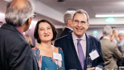 Eduardo and Erica Campos chat with a fellow Evans event attendee while holding glasses of champagne