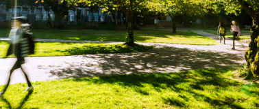 Student walking across green grass