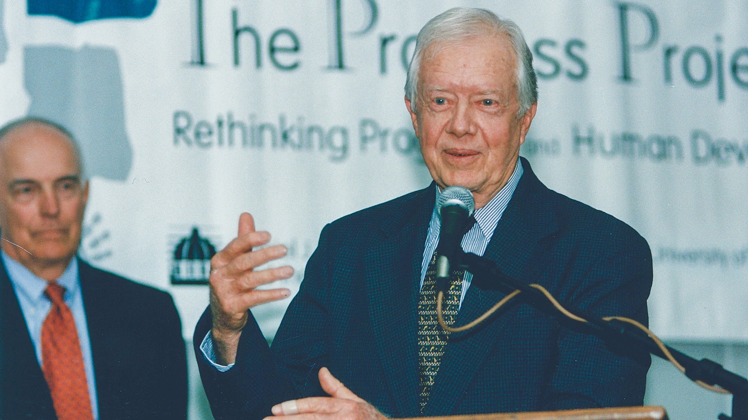 Jimmy Carter speaks from podium with Dan Evans in background