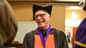 Pat Dobel wearing doctoral robes at Evans School graduation
