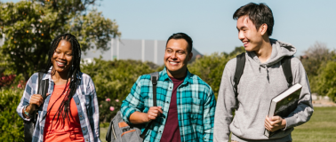 Three students walk across community college campus