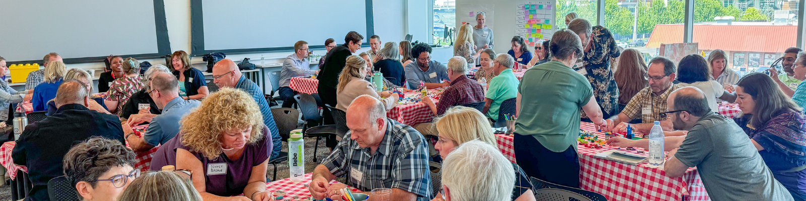 WA-CELI participants work in small groups at tables with checkered table cloths