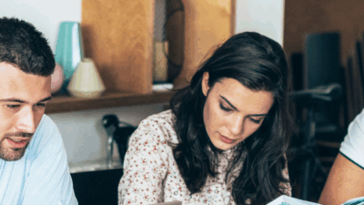 Five students sit around a table studying