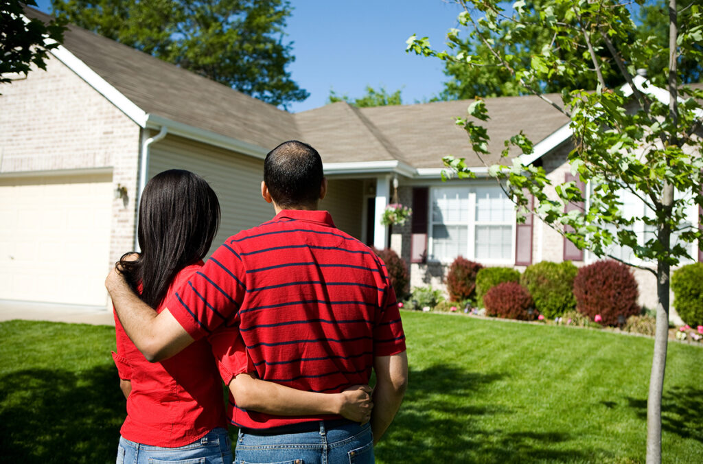 Two people standing outside a suburban single family home