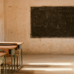 An empty classroom with wooden desks and a blackboard