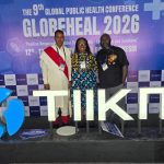 Three IPPHL alums stand in front of a banner with the works Globeheal 2026.